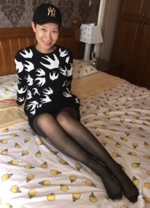 长腿女人戴帽子在家中床上展示