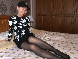 长腿女人戴帽子在家中床上展示