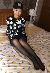 长腿女人戴帽子在家中床上展示