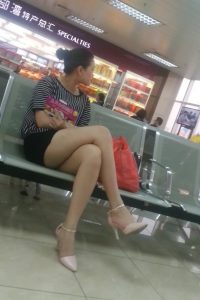 火车站坐在候车室的成熟女人在翘起腿时被抓拍