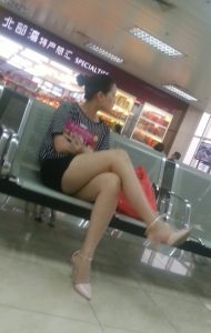 火车站坐在候车室的成熟女人在翘起腿时被抓拍