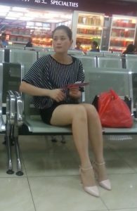 火车站坐在候车室的成熟女人在翘起腿时被抓拍