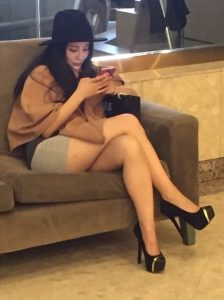在酒店大堂坐着的一位时尚美女的恨天高美腿