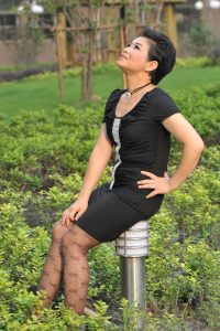 穿灰色花纹丝袜的短发阿姨在公园里拍照片