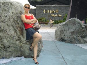 熟女甜甜带墨镜在景区内秀美腿拍照片