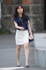 娇小的上班女郎脚踩高跟手持苹果手机走路上班