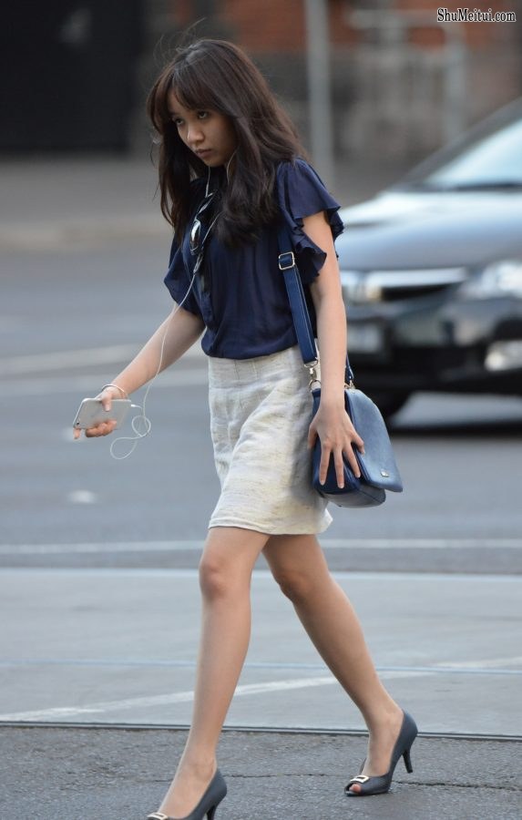 娇小的上班女郎脚踩高跟手持苹果手机走路上班[第2张/共4张]