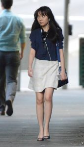 娇小的上班女郎脚踩高跟手持苹果手机走路上班