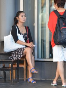 街头吸烟的妇女抬起光滑的玉腿的瞬间