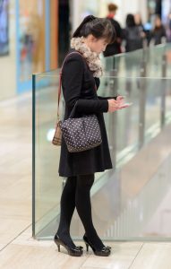 穿黑色裤袜高跟鞋在电影院边等人的年轻女人