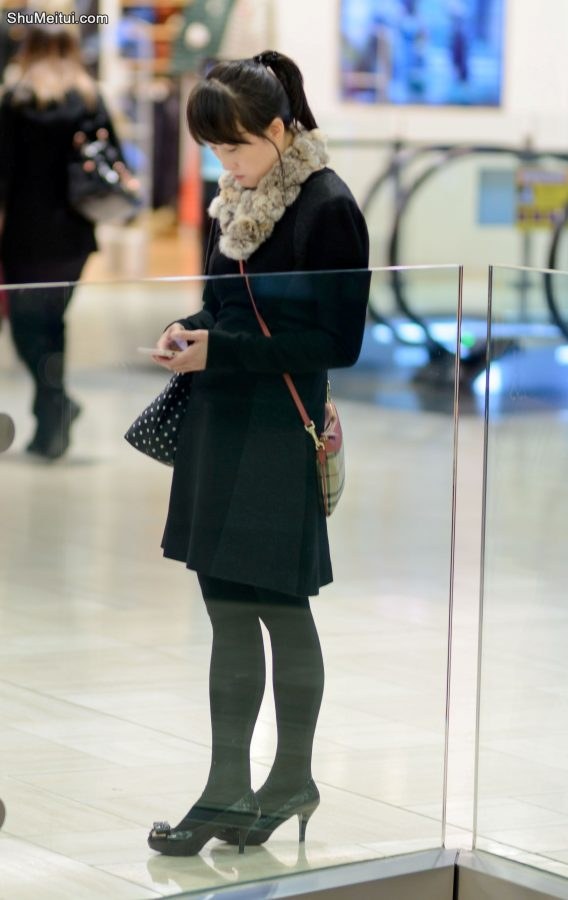 穿黑色裤袜高跟鞋在电影院边等人的年轻女人[第1张/共4张]