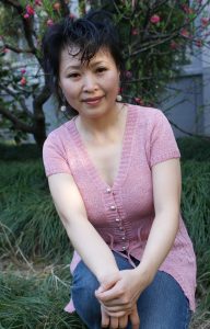 成熟风韵的大姐穿V领衫牛仔裤在湖边拍照