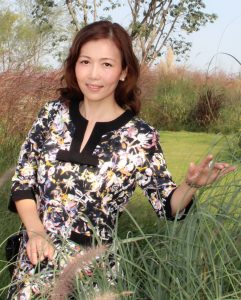 美丽的姐姐坐在湖边的草坪上展示她完美无瑕的长腿和美足